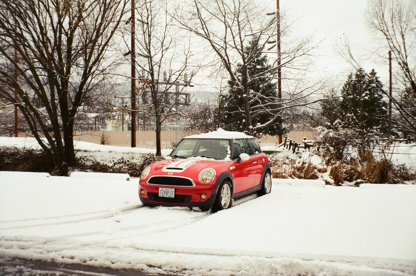 A photo of a red mini cooper in the snow