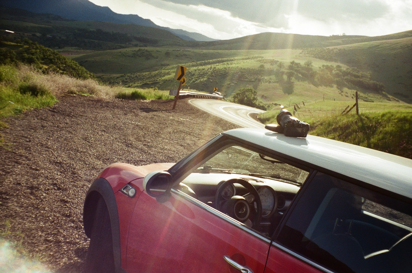 A photo of a red mini cooper, a camera, rogue valley, and sun beams