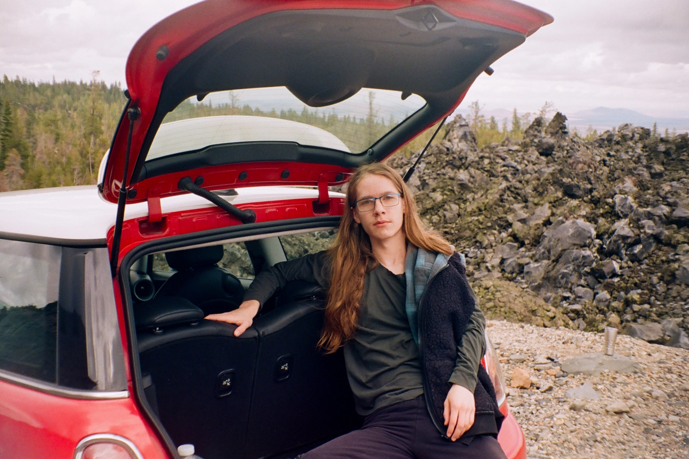 A photo of a man sitting in the trunk of a car