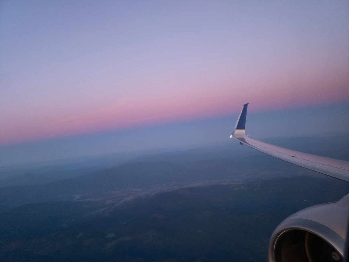 A photo of a pink sky from an airplane