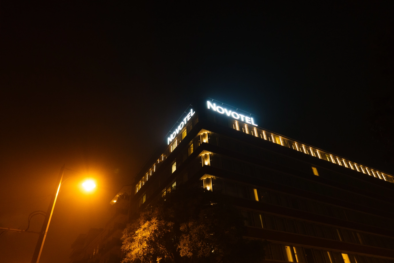 A photo of the Novotel building in Budapest at night
