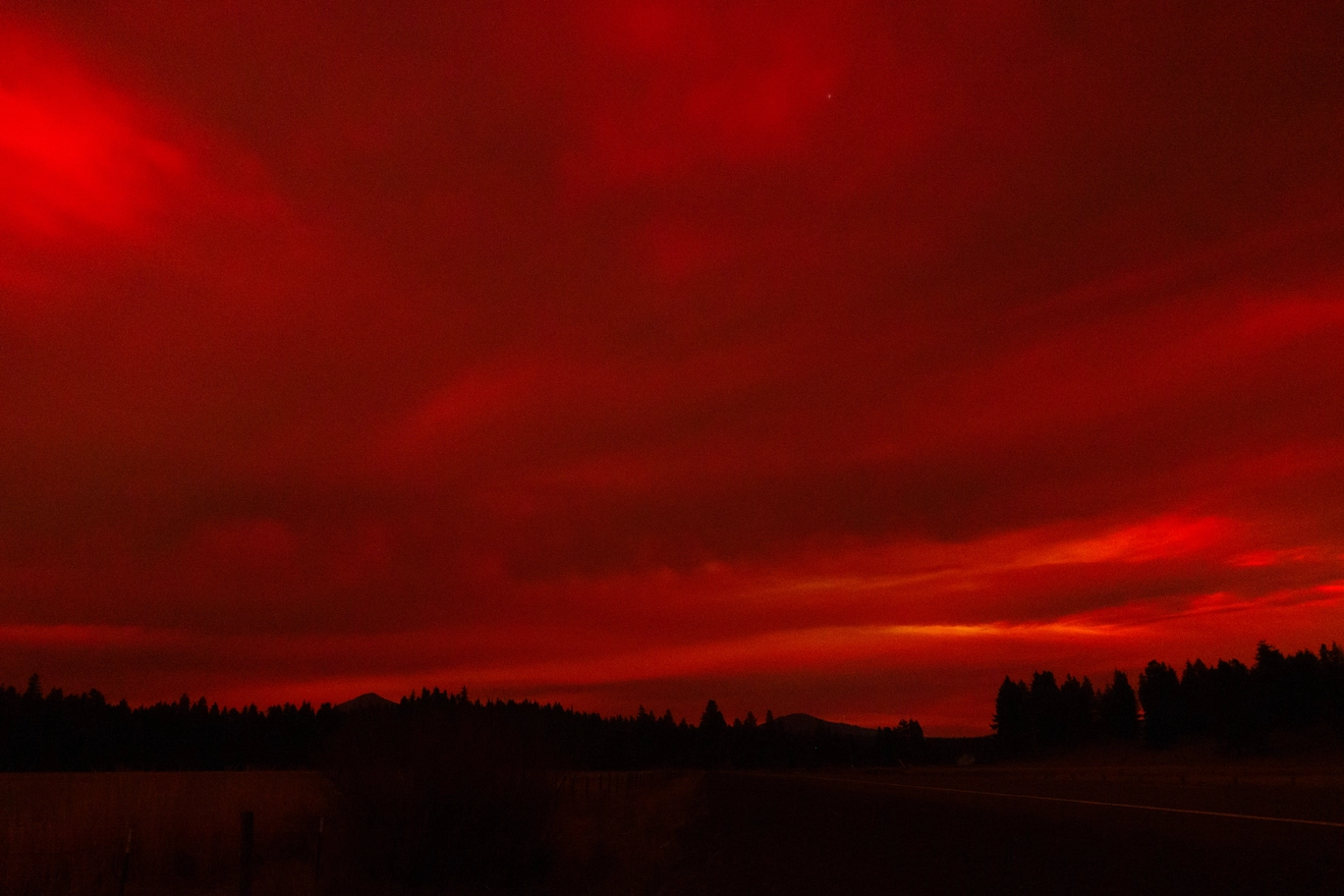 A photo of red clouds covering the sky at night due to the Aurora Borealis