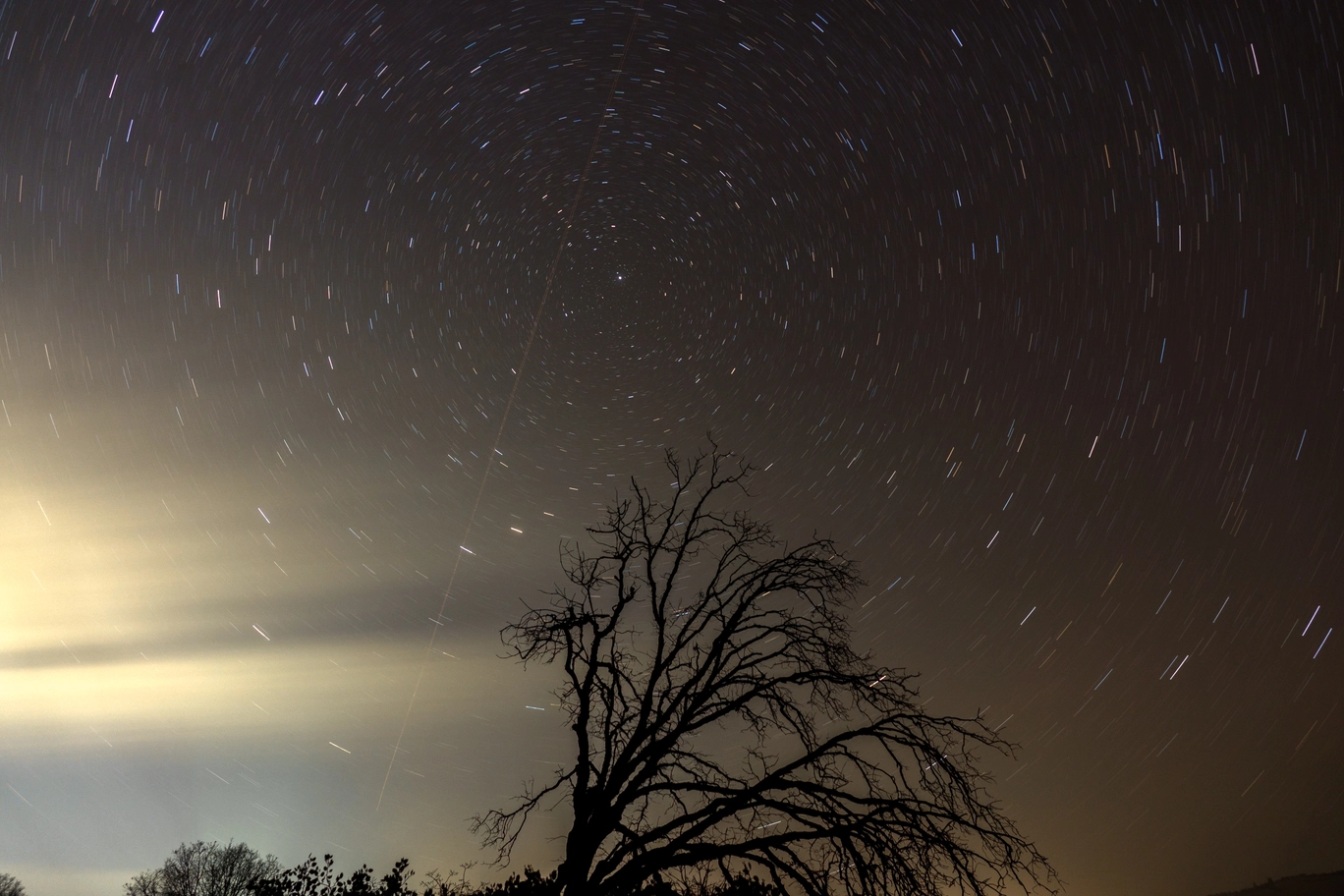 A photo of stars streaking around the north star