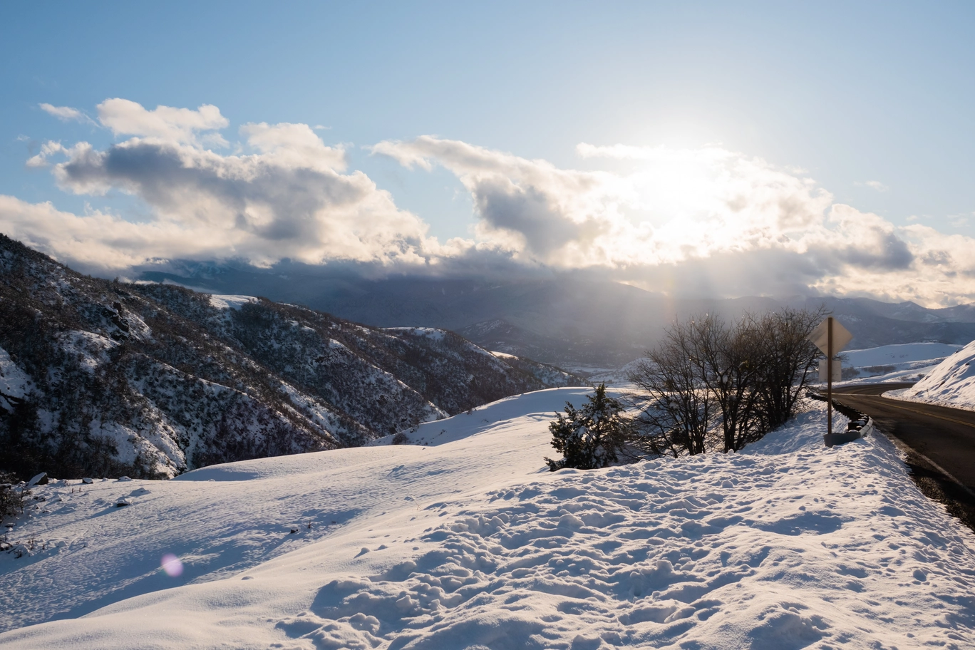 A photo of snowy mountains and the sun