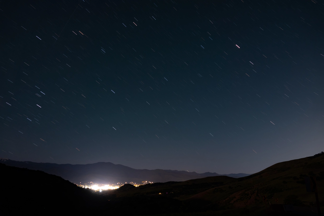 A photo of Ashland from afar with stars streaking across the sky