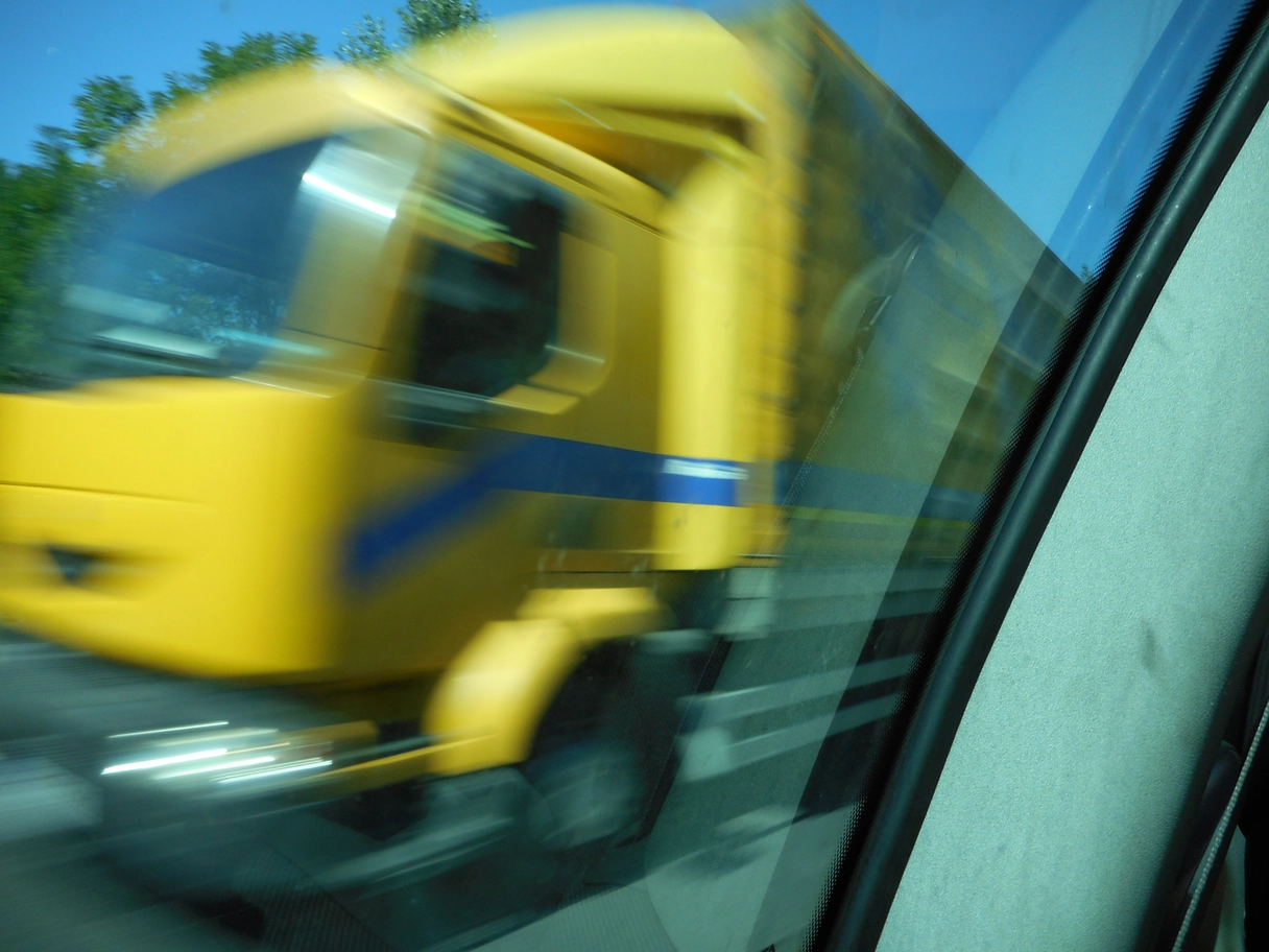 A photo of a yellow truck speeding by