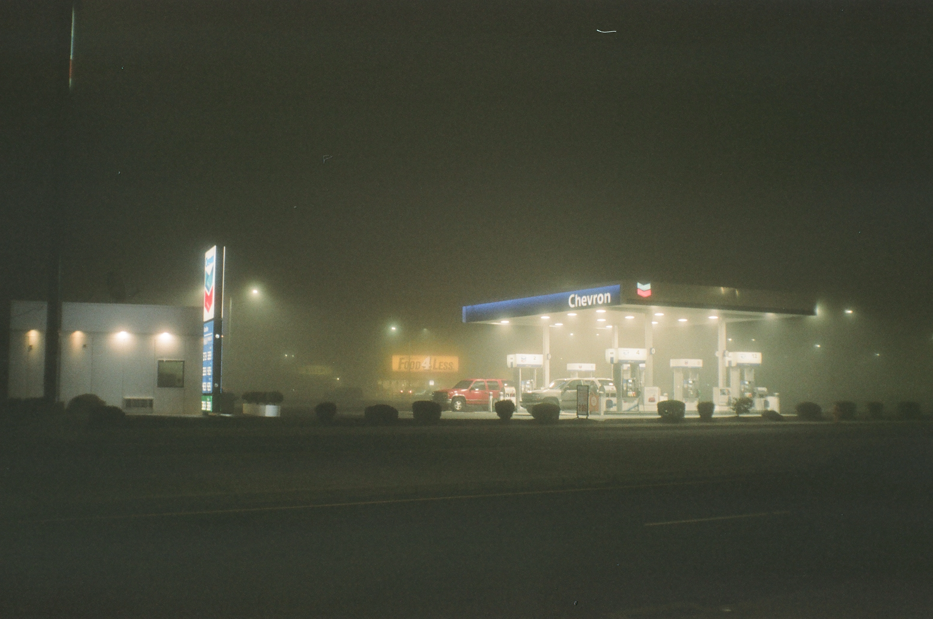 A photo of a gas station at night during heavy fog