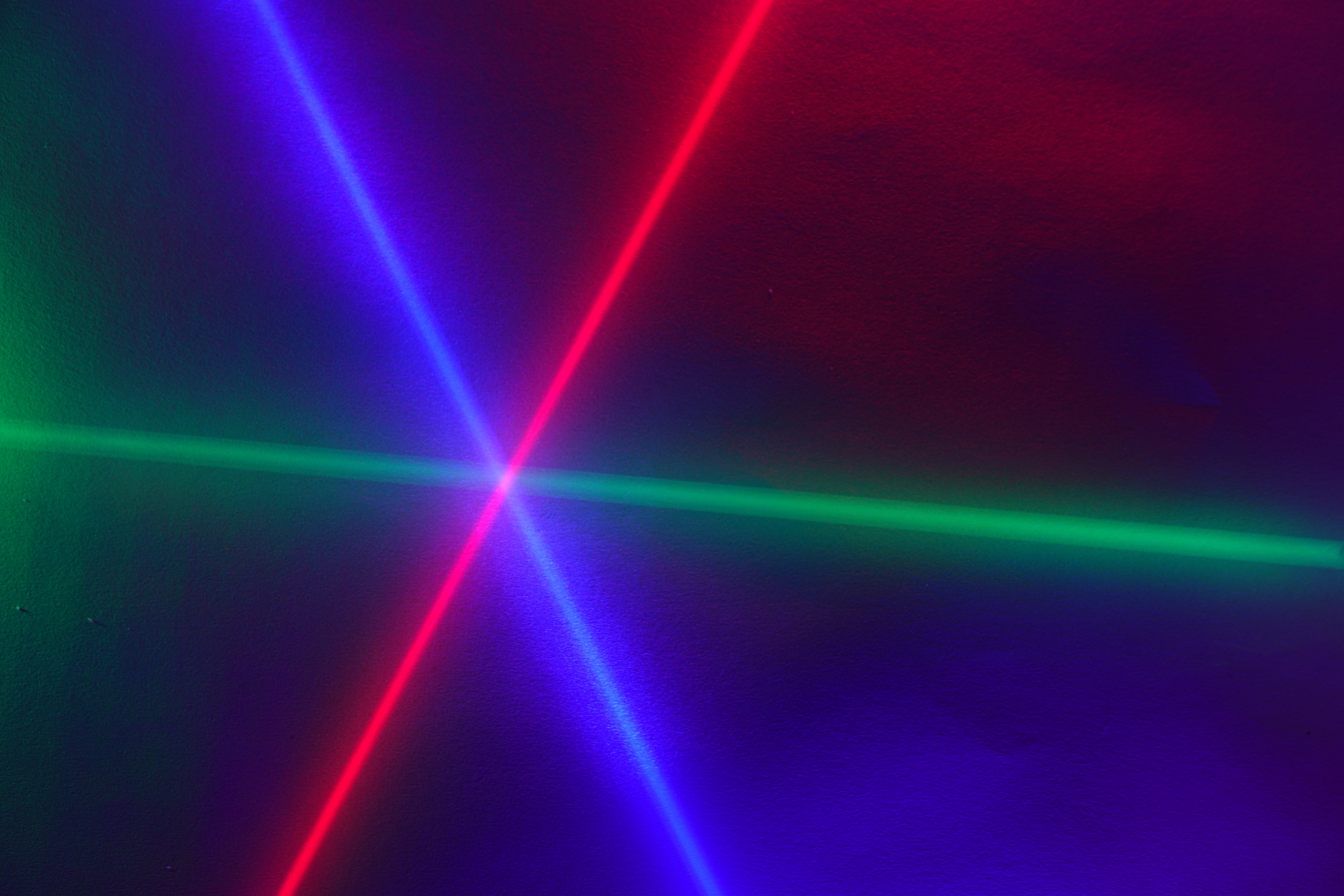 A photo of red, green, and blue laser beams intersecting