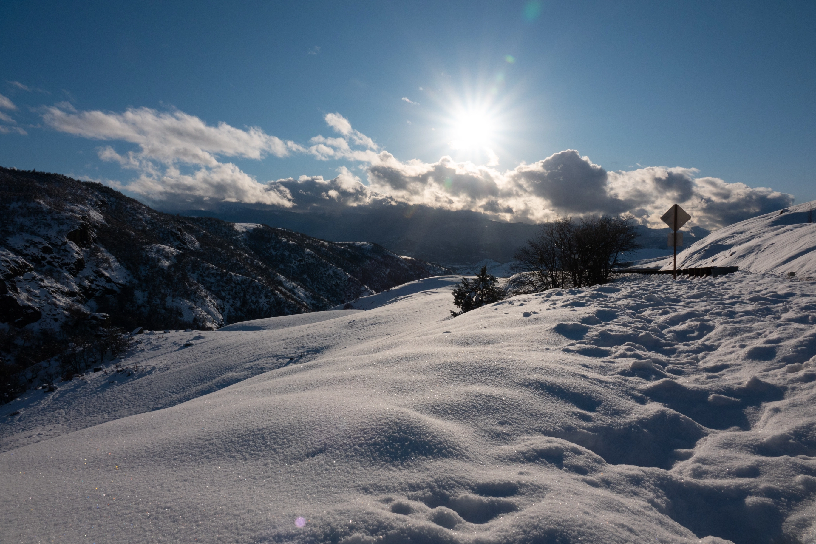 A photo of snowy mountains and the sun