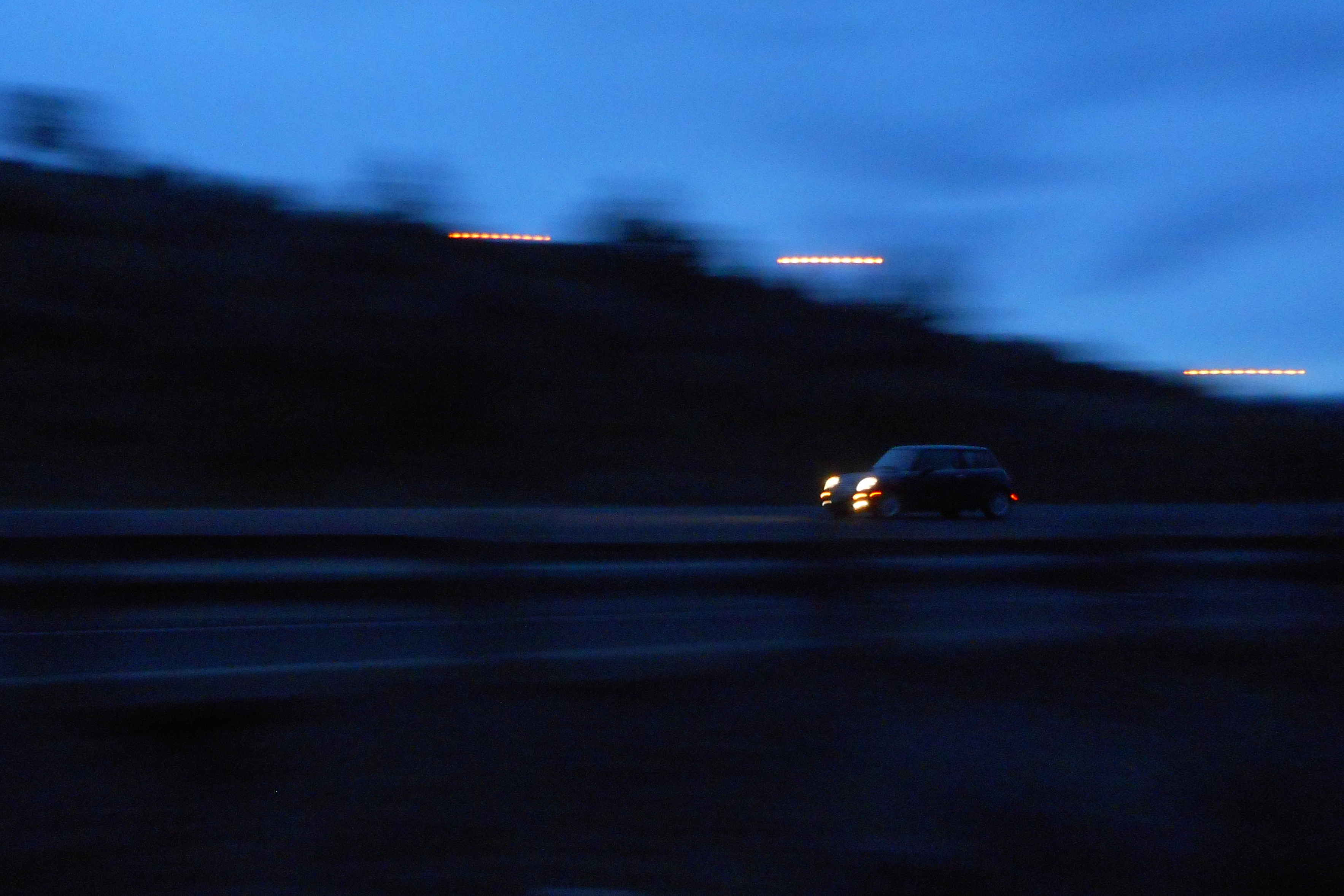 A photo of a black mini cooper on the highway